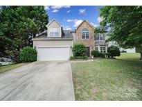 Charming two-story home with stone accents, landscaped yard, and attached two-car garage on a sunny day at 2017 White Cedar Ln, Waxhaw, NC 28173