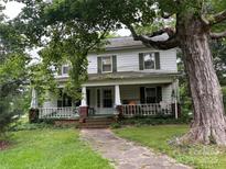Charming two-story home with a large front porch and lush landscaping at 208 E Main St, Cleveland, NC 27013