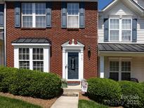 Inviting townhome with brick facade, blue shutters, and a well-maintained lawn and welcome front door at 2147 Lake Breeze Ln, Denver, NC 28037