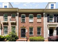 Charming brick townhome featuring a black front door, well-maintained landscaping, and large windows for natural light at 2485 Shanklin Ln, Denver, NC 28037