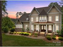 Elegant two-story home featuring a stone foundation, inviting porch, and manicured lawn at twilight at 270 Kemp Rd, Mooresville, NC 28117