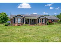 Charming brick home featuring well-manicured lawn, bay windows, and welcoming front porch at 5873 Alexis Ln, Vale, NC 28168