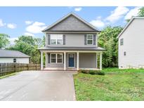 Charming two-story home features a blue front door, covered porch with white columns, and a well-maintained yard at 668 Smith St, Kannapolis, NC 28083