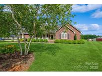 Charming brick home with a well-manicured lawn and lush landscaping at 8520 Wright Rd, Kannapolis, NC 28081