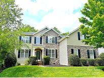 Charming two-story home featuring stone accents, black shutters, and lush landscaping for great curb appeal at 10008 King George Ln, Waxhaw, NC 28173