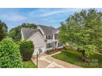Charming two-story home with a well-manicured lawn and basketball hoop on the driveway at 10434 Blackstock Rd, Huntersville, NC 28078