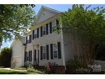 Charming two-story home with gray siding, black shutters, landscaped yard, and manicured greenery at 10434 Blackstock Rd, Huntersville, NC 28078