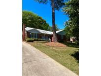 Charming brick home with well-manicured lawn and mature trees creating a beautiful curb appeal at 13416 Four Oaks Ln, Matthews, NC 28105