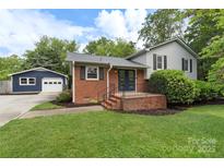 Charming brick home with a well-maintained lawn and a detached blue garage at 15333 Catawba S Cir, Matthews, NC 28104