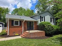 Charming two-story home featuring brick and siding, with a landscaped yard and inviting front porch at 15333 Catawba S Cir, Matthews, NC 28104