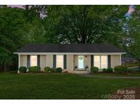 Charming single-story brick home featuring a well-manicured lawn and inviting front entrance with black shutters at 1700 Emerywood Dr, Charlotte, NC 28210