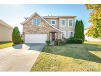 Charming two-story home featuring a stone facade, well-manicured lawn, and a two-car garage at 2441 Chatham Dr, Fort Mill, SC 29707