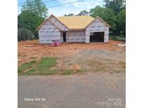 New construction home showing exterior with visible framing and the beginning stages of the roof install at 302 W Second St, Lowell, NC 28098