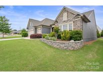 Beautifully landscaped front yard with stone accents and lush green lawn enhance the curb appeal at 3537 Plum St, Fort Mill, SC 29715