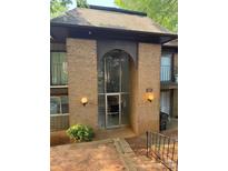 Building entrance with brick facade, glass doorway, unit number and globe lighting fixtures at 417 Orchard Trace Ln # 6, Charlotte, NC 28213