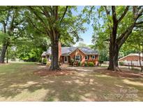 Charming brick home with a landscaped yard shaded by mature trees at 4608 Beatties Ford Rd, Charlotte, NC 28216