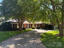 Charming single-story brick home with lush landscaping and a long driveway offering curb appeal at 4815 Sentinel Post Rd, Charlotte, NC 28226