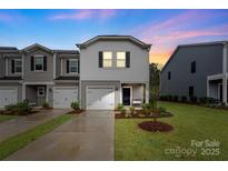 Charming townhome featuring a single-car garage and well-manicured lawn, perfect for suburban living at 518 Tayberry Ln, Fort Mill, SC 29715
