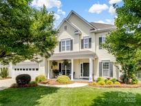 Charming two-story home with a manicured lawn, welcoming front porch, and attached two-car garage at 7627 Woodcrest Dr, Stanley, NC 28164