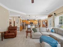 Inviting living room flows into the kitchen, complete with an oversized couch, perfect for entertaining at 7627 Woodcrest Dr, Stanley, NC 28164