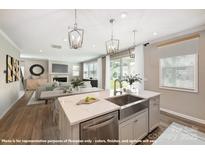 Spacious kitchen with white cabinets, a stainless steel sink, a marble countertop, and seamless views into the living area at 9858 Quercus Ln, Huntersville, NC 28078