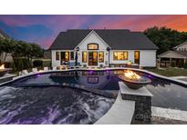 Stunning backyard pool with built-in hot tub and a fire pit in outdoor living space at 120 Lakeshore Dr, Mooresville, NC 28117