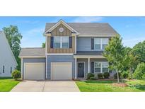 Charming two-story home featuring light blue siding, a two-car garage, and a welcoming front entrance at 129 Canada Dr # 85, Statesville, NC 28166