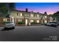 Townhome exterior featuring brick accents, red shutters, and a well-maintained parking area at dusk at 1485 20Th Ne Ave, Hickory, NC 28601