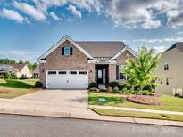 Charming brick home featuring a manicured front yard, two-car garage, and classic architectural details at 15429 Topanga Dr, Charlotte, NC 28278