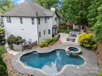 Stunning aerial view of the home's backyard featuring a beautiful pool, hot tub, and outdoor seating area at 19507 Dufour Ct, Cornelius, NC 28031