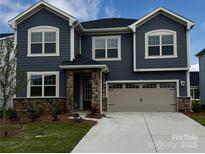 Charming two-story home with blue siding, stone accents, and a two-car garage at 2636 Tillman St, Monroe, NC 28112