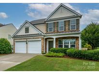 Charming two-story home with stone accents, green shutters, well-manicured lawn and a two car garage at 3224 Dunbar Ln, Fort Mill, SC 29707