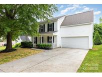 Charming two-story home with a well-manicured lawn, attached garage, and inviting front porch at 3312 James Rd, Charlotte, NC 28215