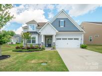 Charming two-story home featuring stone accents, a two-car garage, and a well-manicured front lawn with mature trees at 4015 Havenport Cir, Fort Mill, SC 29708