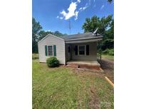 Charming home featuring vinyl siding, a covered front porch, and small landscaped area at 407 Lincoln St, Wadesboro, NC 28170