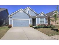 Charming light blue home featuring a two-car garage, well-manicured lawn, and nicely landscaped front yard at 4245 Millstream Rd, Denver, NC 28037