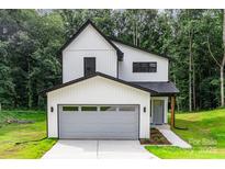 Charming two-story modern farmhouse with vertical siding, black trim, and a gray garage door at 4547 Kings Ct, Hickory, NC 28602