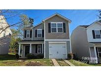 Charming two-story home featuring a one-car garage and landscaped front yard at 5823 Natick Dr, Charlotte, NC 28214