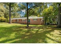 Charming brick ranch-style home with large front yard and mature trees providing ample shade at 709 Plantation Rd, Lancaster, SC 29720