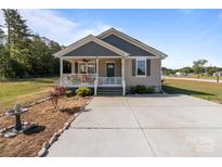 Charming single-story home with a covered porch and a well-maintained front yard with ornamental rocks and concrete driveway at 975 Mt Moriah Church Rd, China Grove, NC 28023