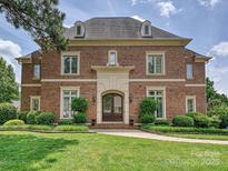 Stately brick home featuring a manicured lawn, classic architectural details, and a welcoming entrance at 11321 James Jack Ln, Charlotte, NC 28277
