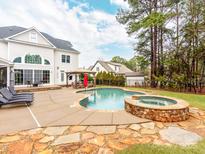 Backyard pool and patio area with a spa and outdoor dining set offer a private outdoor oasis at 123 Yellow Jacket Cir, Mooresville, NC 28117