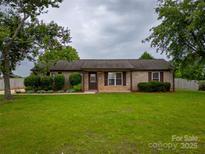 Charming brick home with a well-maintained front yard and mature trees adding to its curb appeal at 133 Pheasant Run Rd, Troutman, NC 28166