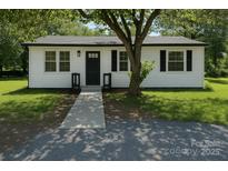 Charming single-story home with white siding, black accents, and a well-maintained front yard and walkway at 1401 Woodman Hall St, Shelby, NC 28152