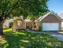 Charming brick home featuring a two-car garage, well-maintained lawn and mature trees at 14336 Northridge Dr, Charlotte, NC 28269