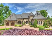 Stunning stone home with a circular driveway, turret, and mature landscaping at 16909 Jetton Rd, Cornelius, NC 28031