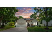Charming single-story home with white siding, manicured lawn, and solar panels at sunset at 1961 Leesburg Dr, Clover, SC 29710