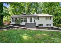 Charming home featuring a landscaped front yard, and a welcoming entrance with freshly painted stairs at 218 Kingsway Cir, Charlotte, NC 28214