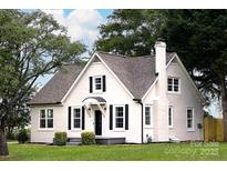 Charming home with a white exterior, black shutters, chimney, and well-manicured lawn at 330 17Th Nw St, Hickory, NC 28601