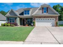 Charming home with a lush green lawn, stone accents, and a spacious two-car garage at 5849 Mcclintock Dr # 117, Denver, NC 28037
